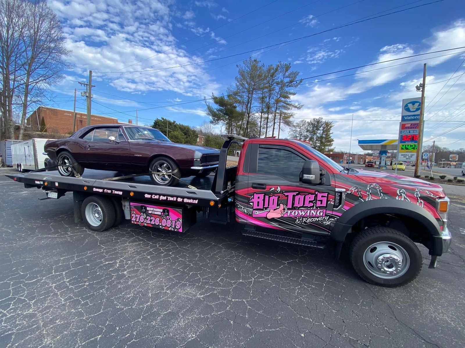 Big Toe's flatbed with an SUV loaded and a sedan in tow